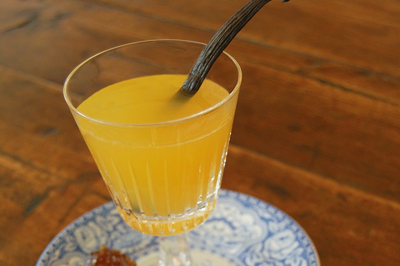Gele wijn in een glas met een kaneelstokje